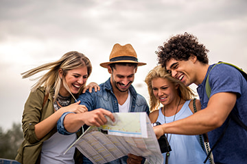 friends smile and look at a map to plan their sightseeing tour